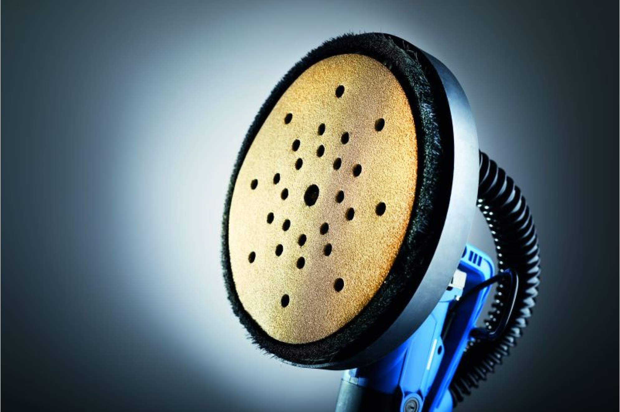 Eine blaue Schleifmaschiene mit einer gelben und löchrig gestanzten Schleifscheibe