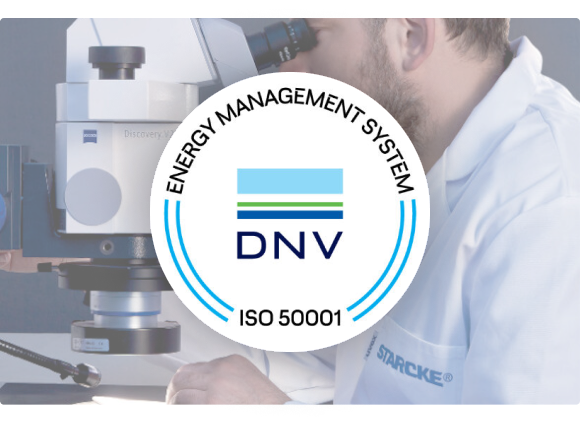 Zertifizierte Sicherheit Im Vordergrund ist ein Logo mit der ISO 50001 Zertifizierung. Ein Mann mit Mikroskop ist im Hintergrund.