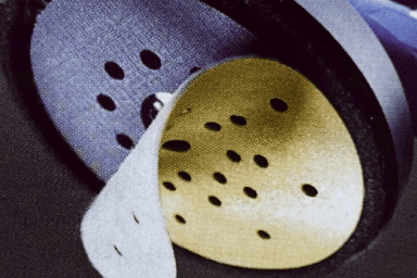 Eine gelbe Schleifscheibe biegt sich vom Schleifkopf
